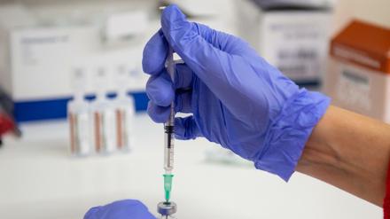 Eine Arzthelferin zieht in eine Spritze eine Kochsalz-Lösung zur Verdünnung von Corona-Impfstoff von Biontech auf.