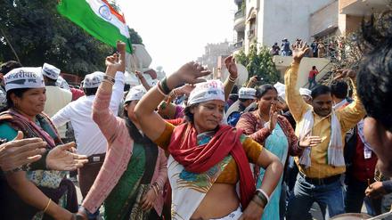 Anhänger der Antikorruptionspartei AAP feiern auf den Straßen Delhis.