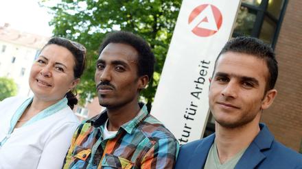 Flüchtlinge aus Afghanistan, Eritrea und Syrien vor einem Schild der Agentur für Arbeit in Hannover.
