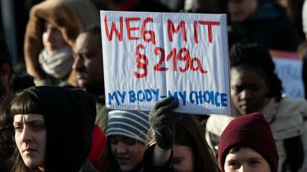 Teilnehmer einer Demonstration zum Internationalen Frauentag gehen durch Berlin und halten dabei ein Schild mit der Aufschrift ´Weg mit Paragraf 219a - My Body - my Choice». 