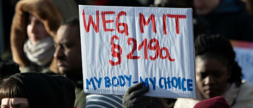 Teilnehmer einer Demonstration zum Internationalen Frauentag gehen durch Berlin und halten dabei ein Schild mit der Aufschrift ´Weg mit Paragraf 219a - My Body - my Choice». 