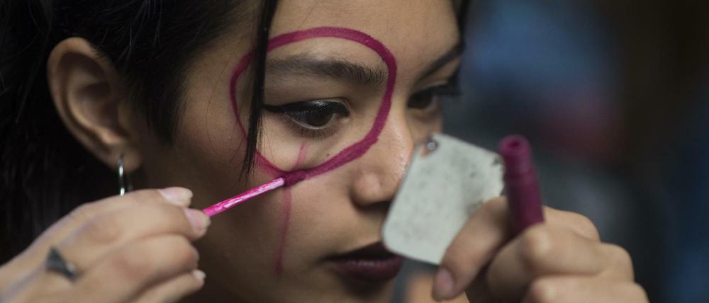 Eine Frau in Buenos Aires bemalt ihr Gesicht während einer Kundgebung zum Frauentag.