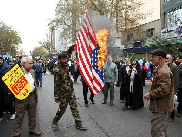 Eine US-Flagge brennt am Jahrestag der Botschaftsbesetzung.