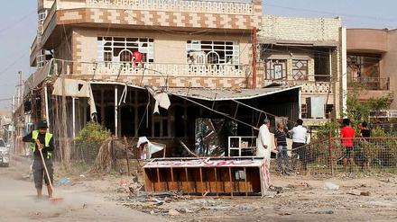 Ein Straßenarbeiter beseitigt die Spuren einer Autobombe in Bagdad. Immer wieder erschüttern Anschläge das Land.