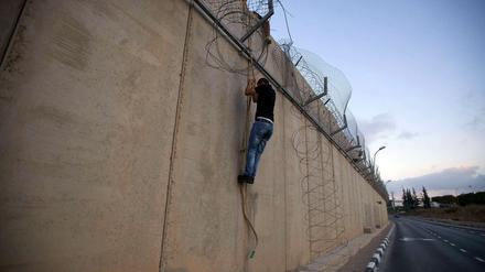 Ein Palästinenser an der umstrittenen Trennmauer in der West Bank.