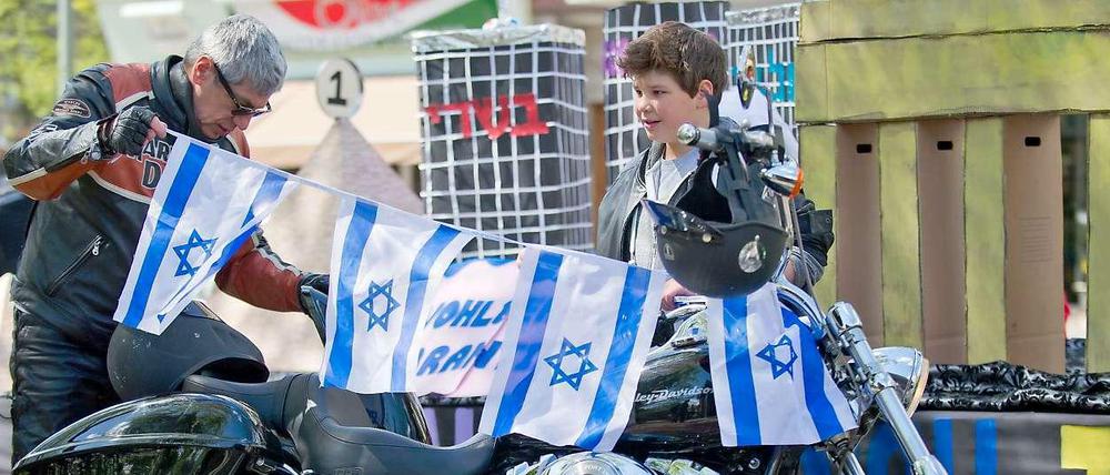 Israelis schmücken bei einer Feier auf dem Olivaer Platz in Berlin ein Motorrad mit israelischen Flaggen. 