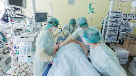 Intensivpflegekräfte versorgen einen Corona-Patienten, der beatmet auf einer Intensivstation liegt.
