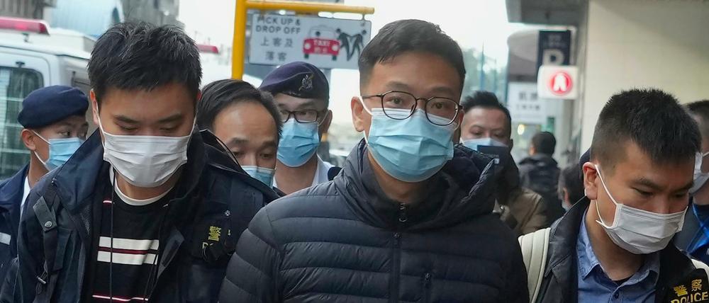 Der Herausgeber von „Stand News“, Patrick Lam (M), wird von Polizeibeamten in Hongkong verhaftet.