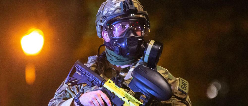 Ein US-Bundespolizist trägt eine Waffe mit Gummigeschossen.