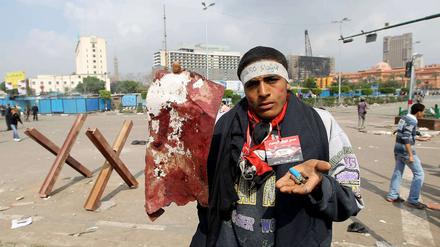 Ein Demonstrant in Kairo hält Patronenhülsen und einen angeblich Blut getränkten Fetzen in den Händen.