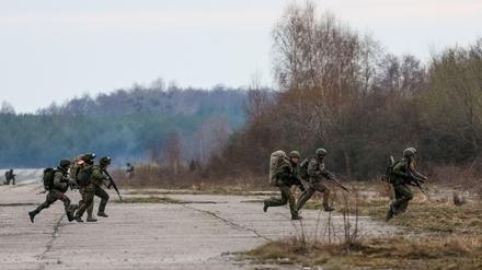 Bei einer Militärübung läuft eine Gruppe Soldaten über ein freies Feld. 