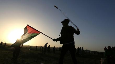 Palästinensische Demonstranten schleudern Steine und halten Flaggen bei Zusammenstößen mit israelischen Soldaten. Archivbild vom Januar.