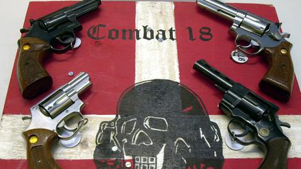 Sichergestellte Waffen und ein Schild der kriminellen Neonazi-Gruppe Combat 18 liegen im schleswig-holsteinischen Landeskriminalamt (LKA).