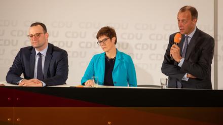 Eine(r) wird gewinnen. Die Kandidaten für Merkels Nachfolge auf Vorstellungstour, Jens Spahn, Annegret Kramp-Karrenbauer und am Mikrofon Friedrich Merz