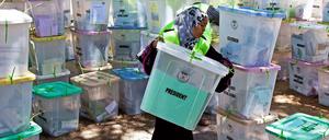 Eine Wahlhelferin trägt eine Wahlurne in Mombasa. Dort waren die Wahllokale teilweise noch bis Dienstagmorgen geöffnet, weil die Schlangen zum offiziellen Schließungszeitpunkt immer noch kilometerlang waren. 