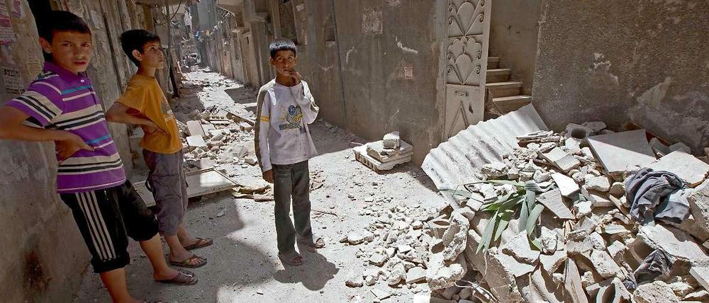 Kinder vor einer Ruine in Damaskus.