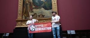 Zwei Umweltaktivist:innen stehen mit einem Banner in der Gemäldegalerie Alte Meister an Raphaels „Sixtinischer Madonna“.