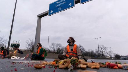 Gegen Lebensmittelverschwendung. Klimaaktivisten der Gruppe "Aufstand der letzten Generation" auf der Fahrbahn der Autobahn A100 vor der Ausfahrt Beusselstraße.