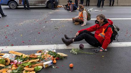 Klimaaktivisten blockieren die Fahrbahn der A100 in Berlin, um gegen Lebensmittelverschwendung zu protestieren. 