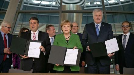 Die drei Parteichefs Merkel, Seehofer, Gabriel unterschreiben den Koalitionsvertrag - vorläufig.