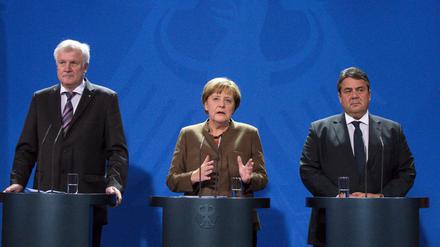 Bundeskanzlerin Angela Merkel, der CSU-Vorsitzende Horst Seehofer (l) und SPD-Vorsitzender Sigmar Gabriel (r) geben Einigung auf Asylverschärfung bekannt.