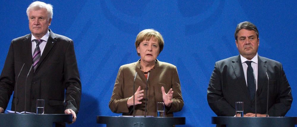 Bundeskanzlerin Angela Merkel, der CSU-Vorsitzende Horst Seehofer (l) und SPD-Vorsitzender Sigmar Gabriel (r) geben Einigung auf Asylverschärfung bekannt.
