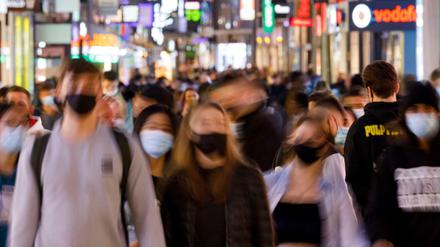 Menschen laufen in einer Fußgängerpassage, wo aufgrund des engen Abstandes zwischen den Passanten Maskenpflicht gilt. (Symbolbild)