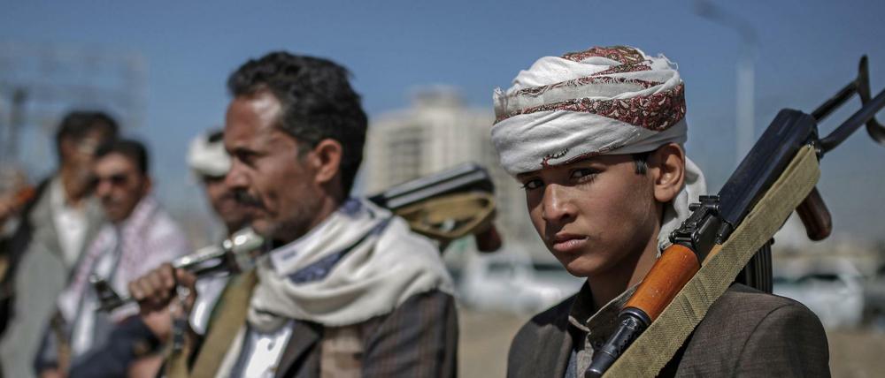 Huthi-Rebellen halten während einer Versammlung ihre Waffen. 