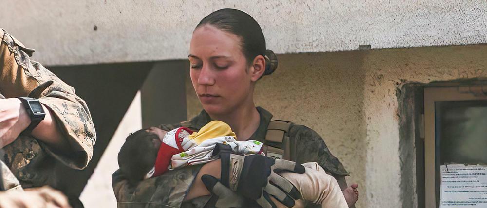In diesem Bild vom 20. August 2021, das vom US Marine Corps zur Verfügung gestellt wurde, beruhigt Nicole Gee ein Baby in Kabul.