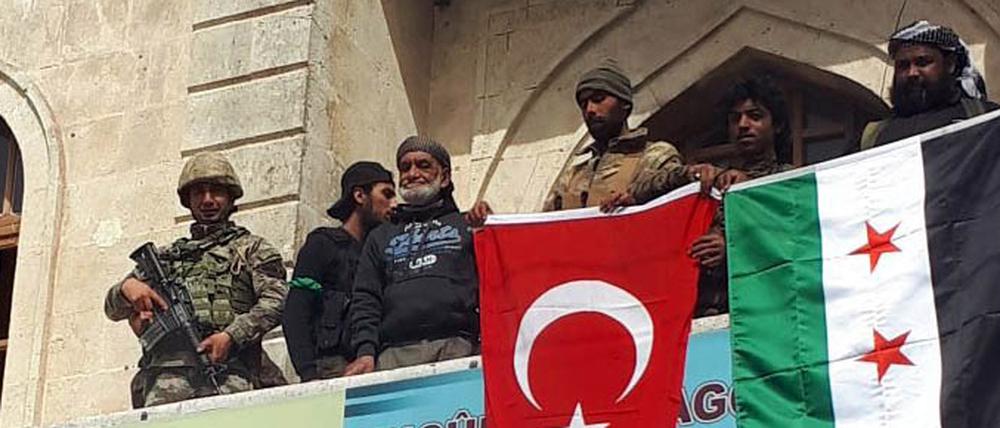 Eine türkische und eine FSA-Flagge im Stadtzentrum von Afrin.