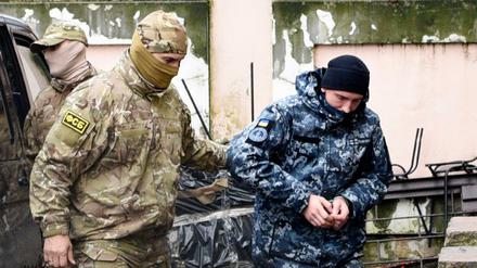 Nach der Festnahme im November 2018 führt ein Offizier des russischen Geheimdienstes FSB (links) einen ukrainischen Marinesoldaten ab. 