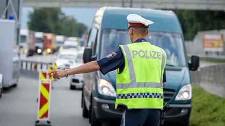 Ein Polizist kontrolliert an einer österreichischen Grenzkontrollstelle die aus Deutschland einreisenden Fahrzeuge.
