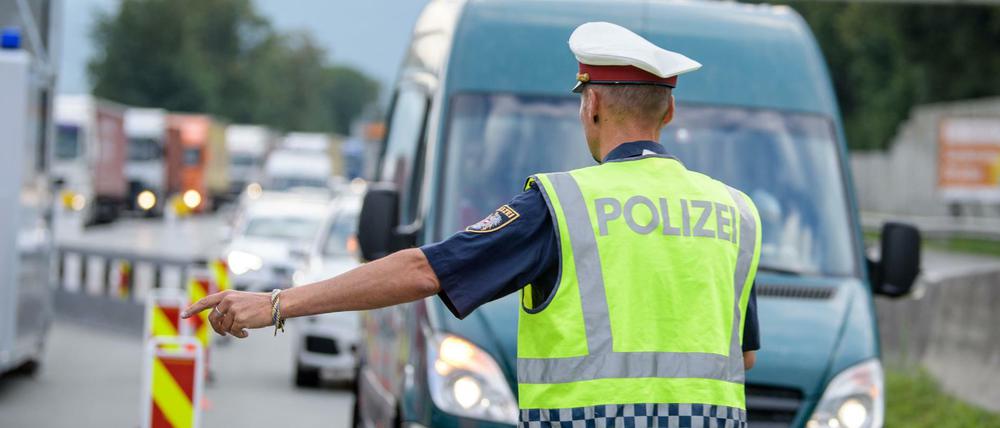 Ein Polizist kontrolliert an einer österreichischen Grenzkontrollstelle die aus Deutschland einreisenden Fahrzeuge.