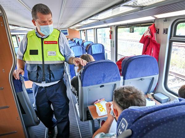 Sachsen, Leipzig: Ein Mitarbeiter der Deutschen Bahn kontrolliert in einem Zug das Tragen von Mund-Nasen-Bedeckungen.