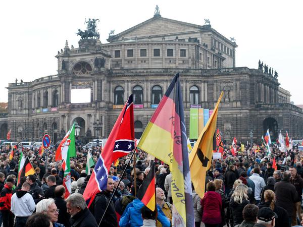 Demonstranten der Pegida haben sich am 19.10.2015 in Dresden (Sachsen) vor der Semperoper versammelt. Vor einem Jahr ging Pegida (Patriotische Europäer gegen die Islamisierung des Abendlandes) in Dresden erstmals auf die Straße. Mit einer Jubiläumskundgebung will sich das fremdenfeindliche Bündnis jetzt feiern. 