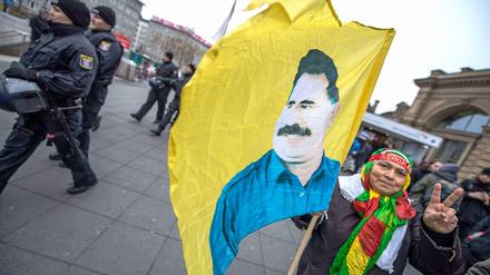 Eine Kurdin trägt in Frankfurt am Main eine Fahne mit dem Konterfei des PKK-Gründers Abdullah Öcalan.