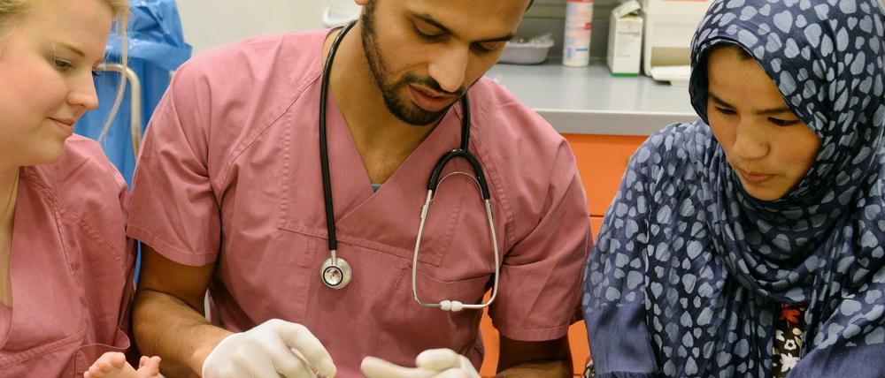2016 im im Gesundheitszentrum der Landesaufnahmestelle für Flüchtlinge in Halle/Saale: Die damals fünf Monate alte Zeinab, die ihre Mutter Madineh (rechts) auf der Flucht von Afghanistan nach Deutschland im Iran geboren hat, bekommt die Sechsfach-Impfung vom Arzt Nomagy Oweida. 