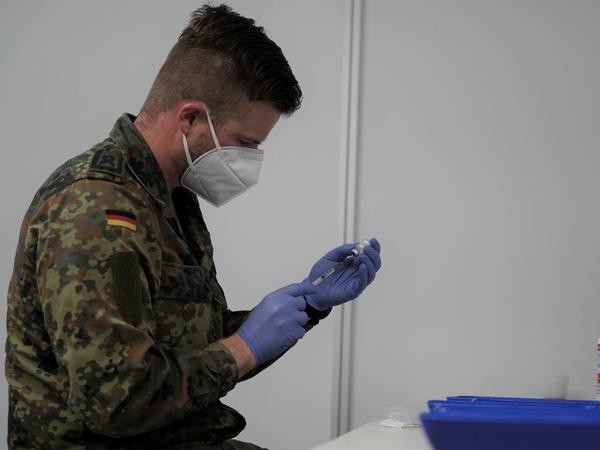 Ein Soldat bereitet eine Spritze für die Impfung vor.