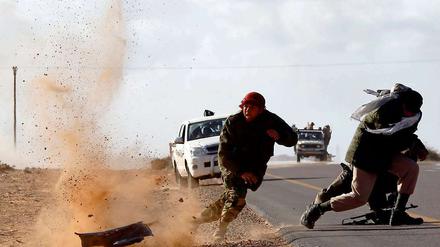 06.03.2011: Rebellen rennen nahe der Stadt Bin Jawad unter heftigen Granatenbeschuss um ihr Leben.