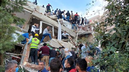 Bewohner und Helfer suchen nach Überlebenden in eingestürzten Gebäuden im türkischen Izmir.