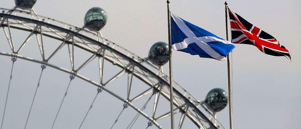 Friedlich vereint. Die schottische Flagge und der Union Jack wehen nebeneinander vor dem Riesenrad "London Eye" in der britischen Hauptstadt.