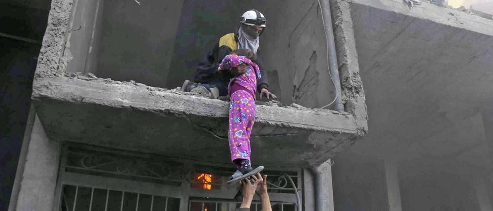 Ein Mädchen in Ost-Ghuta wird nach Luftangriffen aus einem zerstörten Gebäude gerettet. 