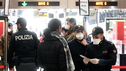 Polizei kontrolliert vor den Gleisen am Mailänder Hauptbahnhof die Reisegründe der Fahrgäste.