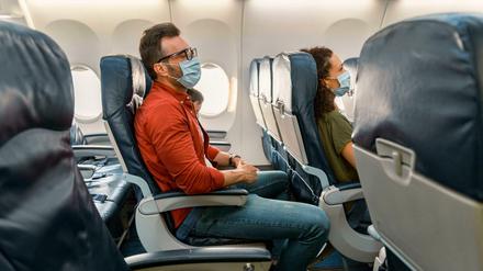 Flugpassagiere tragen Mund-Nasen-Schutz während eines Fluges (Symbolbild)