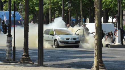 Polizisten löschen am Montag auf den Champs Elysees in Paris das Auto, mit dem Mann zuvor ein Fahrzeug der französischen Gendarmerie gerammt hatte.