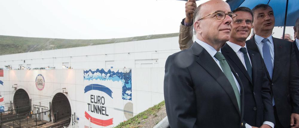 Der französische Premierminister Manuel Valls (Mitte) und Innenminister Bernard Cazeneuve (links) begutachten die Situation am Eurotunnel.