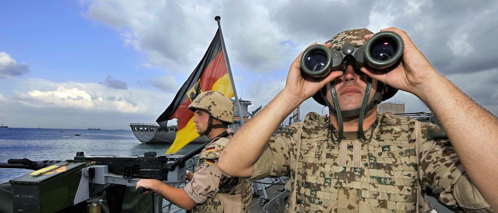 Deutsche Marine-Soldaten halten 2008 an Bord der Fregatte "Karlsruhe" an einem Maschinengewehr Wache.