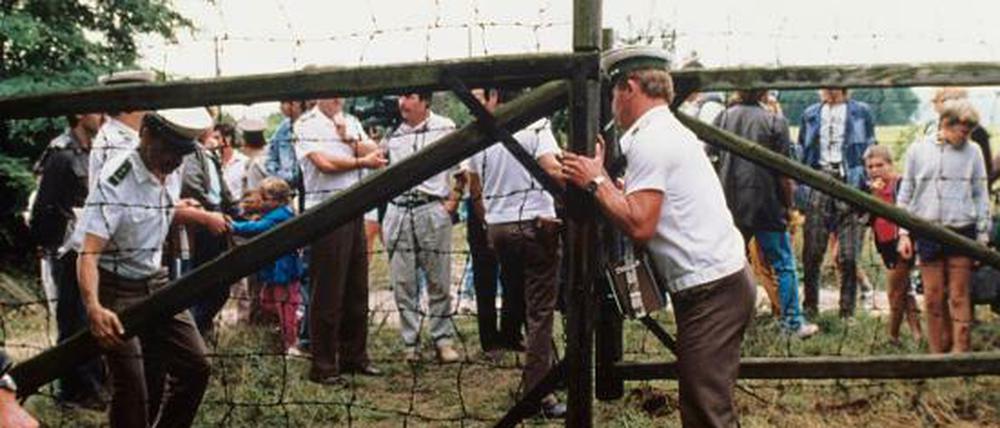 Ein Österreichischer Grenzer öffnet während des Picknicks ein Grenztor (Aufnahme vom 19. August 1989). 