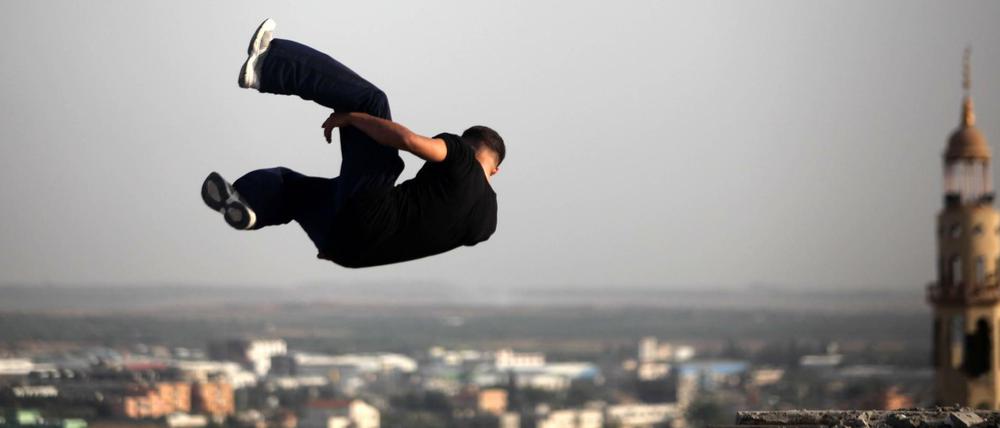 Gewagte Sprünge. Ein Jugendlicher trainiert seine akrobatischen Fähigkeiten inmitten zerstörter Gebäude in Beit Lahia im nördlichen Gazastreifen.  