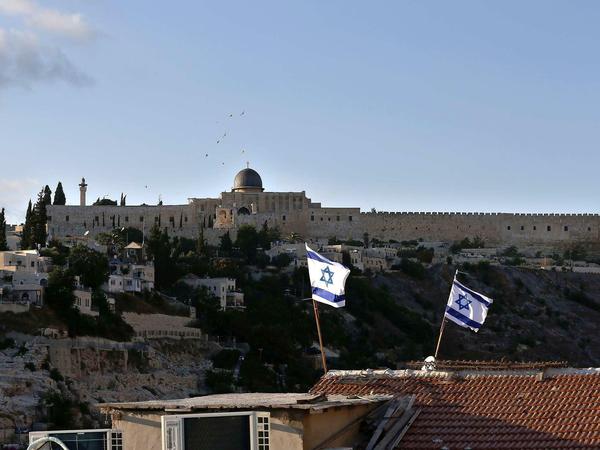 Israelische Flaggen über einem Haus im Osten Jerusalems, im Hintergrund die Al-Aqsa-Moschee. 